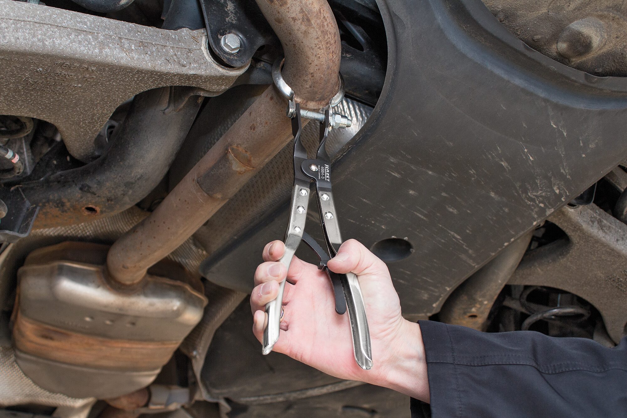 Hazet 4684-3 – detail čelistí a aretace Kleště na spony výfuku Hazet 4684-3 – detail čelistí při práci na sponě